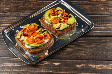 Delicious open-faced sandwiches with fresh vegetables on a silver tray
