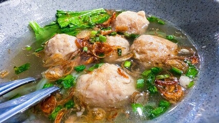 Delicious Bakso Soup with Noodles, Vegetables, and Fried Shallots in Bowl