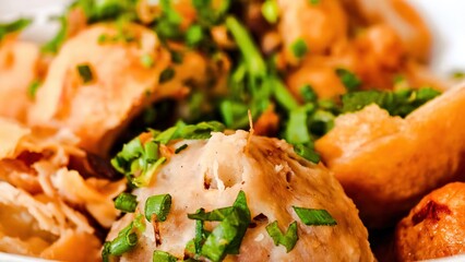 Close-up of delectable fried meatballs adorned with fresh green herbs, a culinary delight