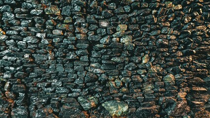 Detailed texture of old rock wall background with weathered surface