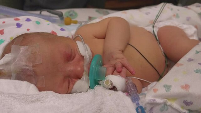 Closeup of Newborn Baby Sucking his Pacifier While in the NICU
