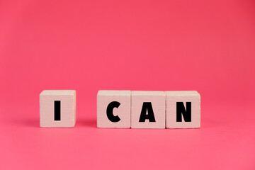 text of I CAN on wooden blocks with pink background. I can do it concept for self belief, positive...