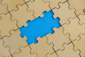 Fototapeta premium white jigsaw puzzle with missing puzzle for a text template. Above photo of isolated on the blue background