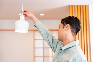 照明をチェックする作業着を着た男性