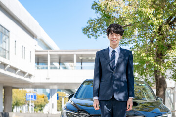 車の前に立つビジネスマン
