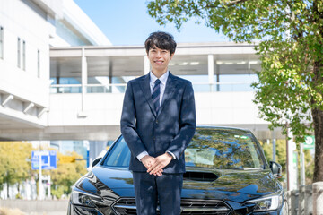 車の前に立つビジネスマン