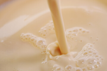 Pouring evaporate milk onto cocktail dessert mixture