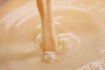 Pouring evaporate milk onto cocktail dessert mixture