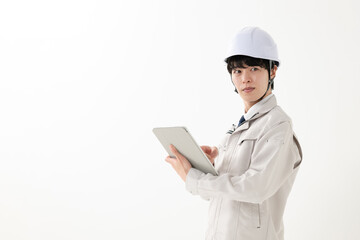 タブレットを持つ作業服の男性