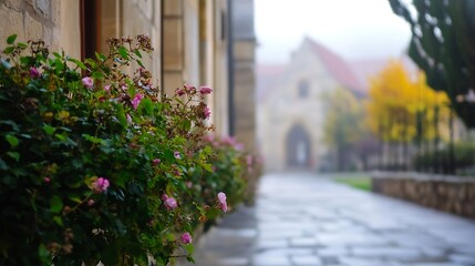 Fototapeta premium Charming Pathway with Flowering Bushes Leading to a Historic Building in Fog : Generative AI