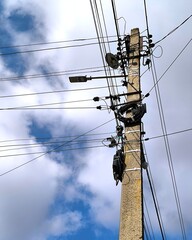 high voltage power lines against a cloudy sky
