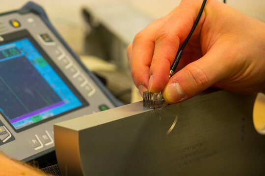 Ultrasonic Testing Equipment Calibration in Industrial NDT Lab: Professional Inspector Setting Up UT Device for Non-Destructive Testing