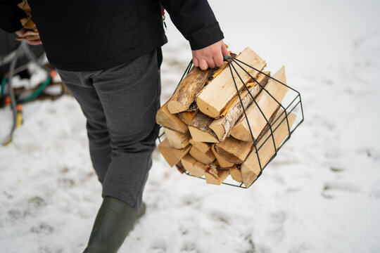 Man bringing fire wood for outdoors stove and fire making
