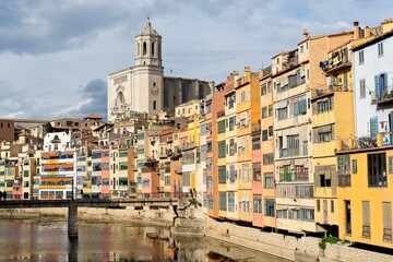Girona Spain - 25 April 2024 - Colourful houses along Onyar River in front of cathedral in Girona