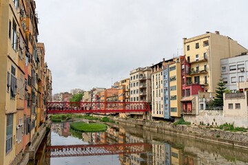 Fototapeta premium Girona Spain - 27 April 2024 - The Iron Bridge (Pont de les Peixateries Velles or Pont de Eiffel) over River Onyar in Girona