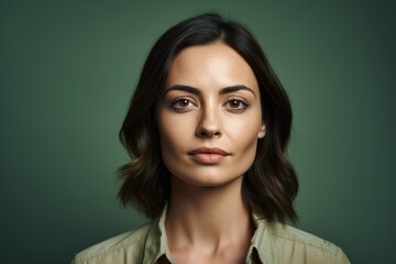 Portrait of a beautiful woman looking at the camera on a green background