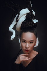 Studio portrait of young woman with white snake