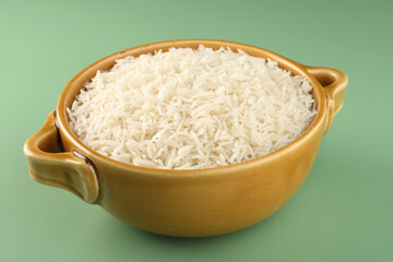 Rice in a ceramic cutlery on light green background
