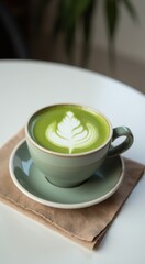 Fototapeta premium Cup of green tea on a saucer on a napkin