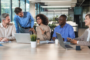 Group of young modern people using modern technologies while working in the creative office
