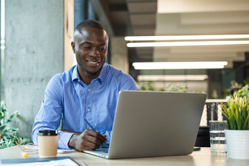 Smiling friendly handsome male call center operator working on hot line with clients