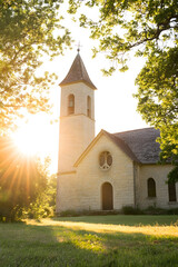 Naklejka premium Rural Stone Church With Steeple and Sunlight Streaming Through Trees Creating a Warm Summer Atmosphere : Generative AI