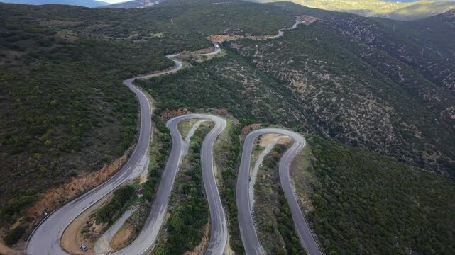Aerial view of a winding road with numerous twists and turns meandering through the mountainous terrain of the Taygetus Mountains in the Peloponnese, Greece.