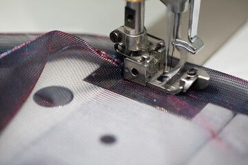 A CloseUp Image of a Sewing Machine Actively Stitching Through Colorful Fabric for Garment Creation