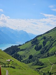 A stunning summer photo of Brienzer Rothorn, one of Switzerland’s most beautiful peaks, showcasing its majestic view over the surrounding Swiss Alps. The image captures the lush green landscapes and v