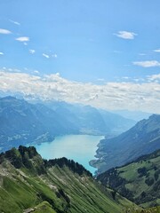 A breathtaking summer photo taken from the summit of Brienzer Rothorn, showcasing the serene beauty of Lake Brienz nestled in the Swiss Alps. The turquoise waters of the lake contrast beautifully with