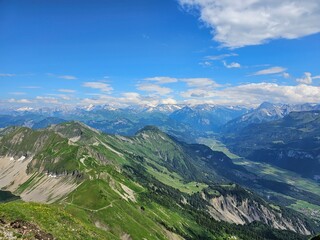 A stunning summer photo of Brienzer Rothorn, one of Switzerland’s most beautiful peaks, showcasing its majestic view over the surrounding Swiss Alps. The image captures the lush green landscapes and v