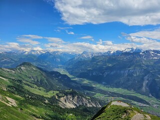 A stunning summer photo of Brienzer Rothorn, one of Switzerland’s most beautiful peaks, showcasing its majestic view over the surrounding Swiss Alps. The image captures the lush green landscapes and v