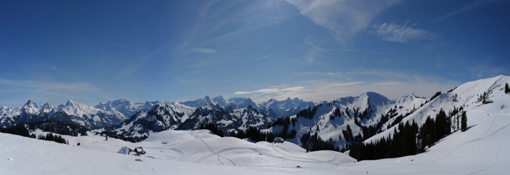 Panorama from the Sparenmoos nature reserve above Zweisimmen in winter with a view of the Swiss Alps