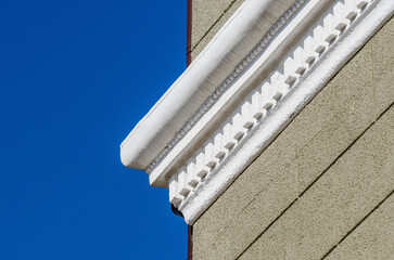  white stucco cornice on a light green plastered cinder block wall © Sofiia