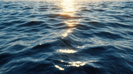 Fototapeta premium A deep blue ocean surface with swirling currents and scattered white foam, viewed from above. Sunlight reflects off the rippling waves, creating a shimmering effect. 