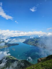 A stunning summer view from Mount Rigi, often referred to as the "Queen of the Mountains," offering panoramic vistas of the Swiss Alps and surrounding lakes. This image captures the lush green meadows