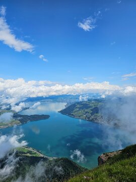 A stunning summer view from Mount Rigi, often referred to as the "Queen of the Mountains," offering panoramic vistas of the Swiss Alps and surrounding lakes. This image captures the lush green meadows