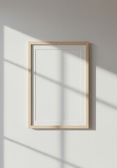 Minimalist Elegance: Blank Frame on a Sunlit Wall