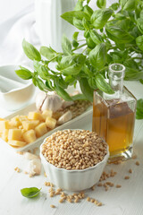 Ingredients for making Pesto sauce on a white wooden table.