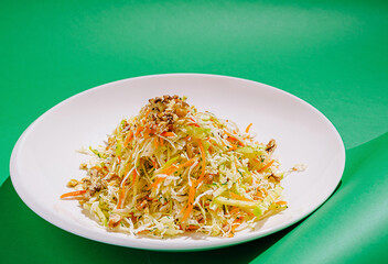 Fresh vegetable salad with walnuts on a vibrant green background