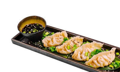 Delicious dumplings served with dipping sauce on a black plate