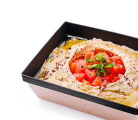 Delicious hummus topped with fresh vegetables and herbs