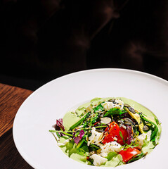 Fresh green salad with tomatoes and seeds in a stylish restaurant