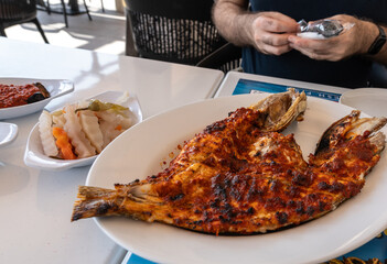 Spicy grilled grouper with a crispy charred surface, served in an Arabic restaurant in the UAE