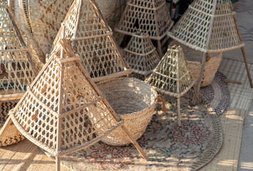 Obraz premium Traditional handmade woven baskets and covers displayed at a craft market, showcasing cultural heritage