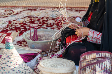 Close-up of hands weaving a basket from reeds, showcasing traditional craftsmanship and cultural...