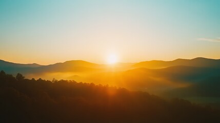 Fototapeta premium Golden sunrise over misty mountain range with soft hues and silhouetted trees