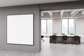 Modern office interior with large blank framed poster on grey wall. 3D Rendering