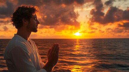A Man Praying During Sunset Near the Ocean