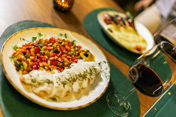 Delicious plate seved in restaurant. Meat in white sauce with vegetables and red wine.